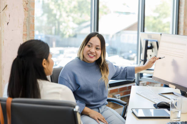 two young adult women work together on project1455980102
